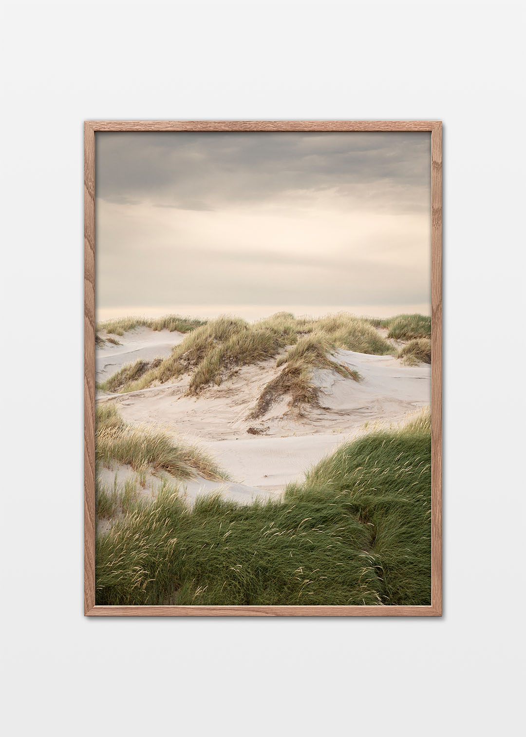 Vestkystens klitter med sand, grønt græs og rolig himmel ved Hvide Sande