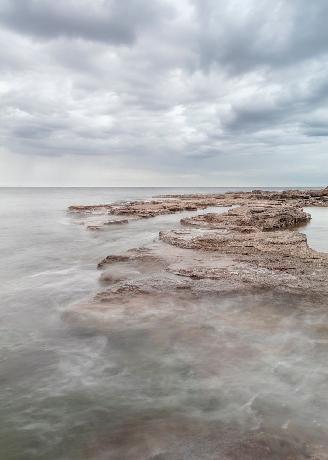 Gotland plakat med lyse flade klipper og roligt hav under skyet himmel – foto Martin Bay.