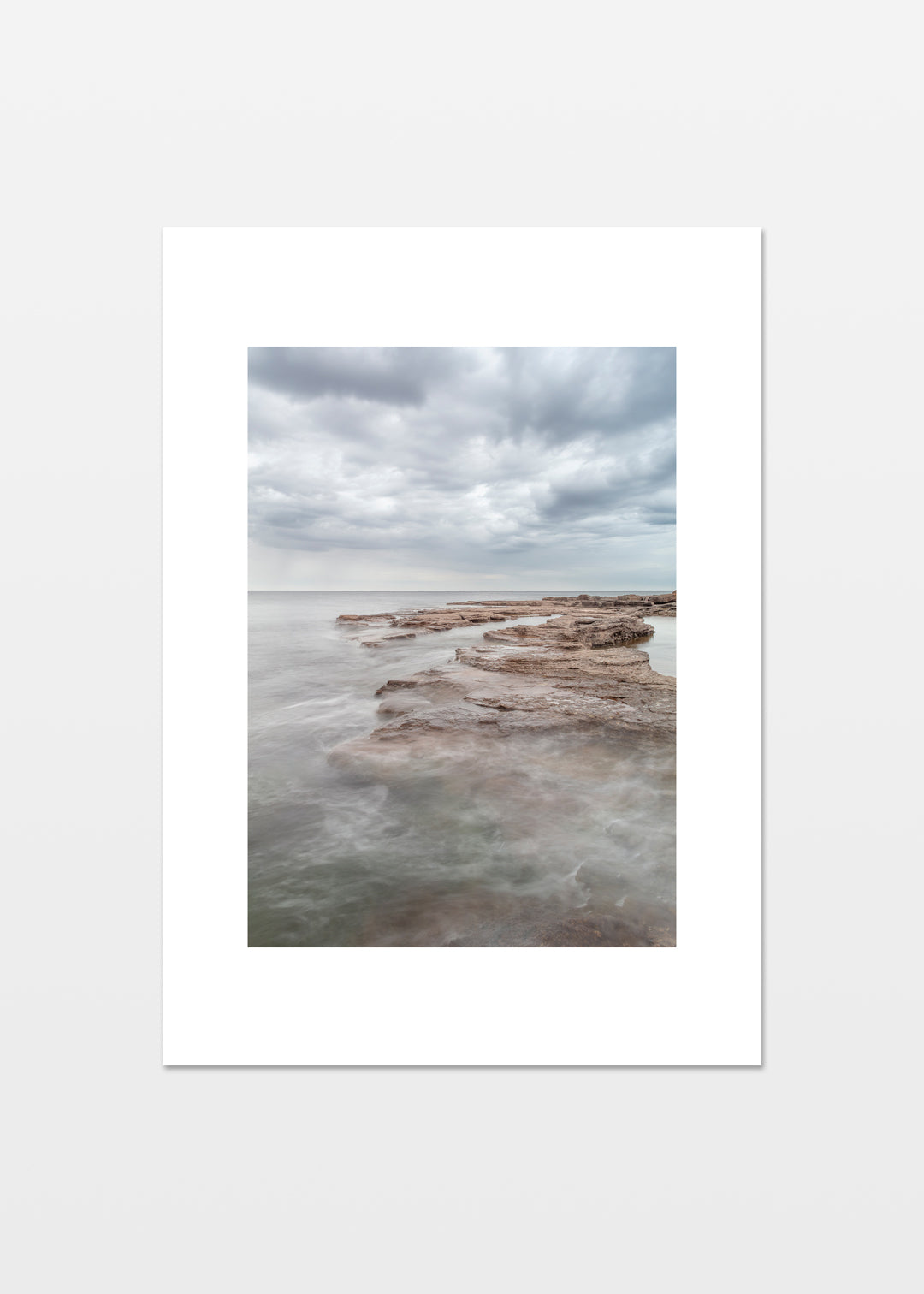 Gotland plakat med lyse flade klipper og roligt hav under skyet himmel – foto Martin Bay.
