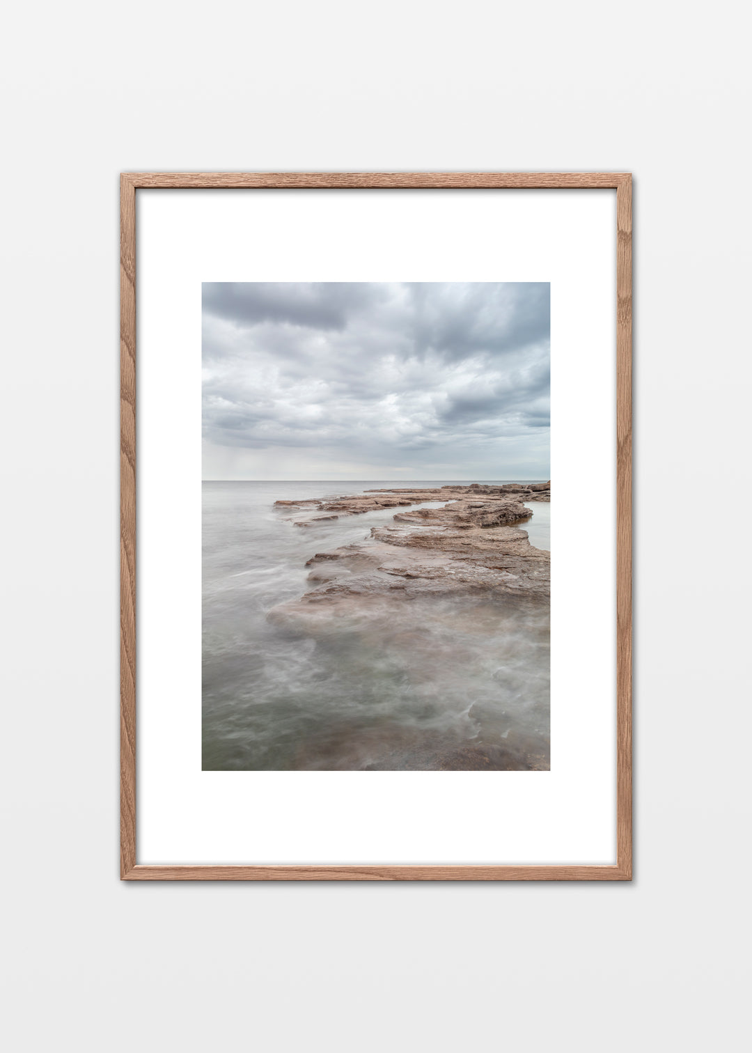 Gotland plakat med lyse flade klipper og roligt hav under skyet himmel – foto Martin Bay.
