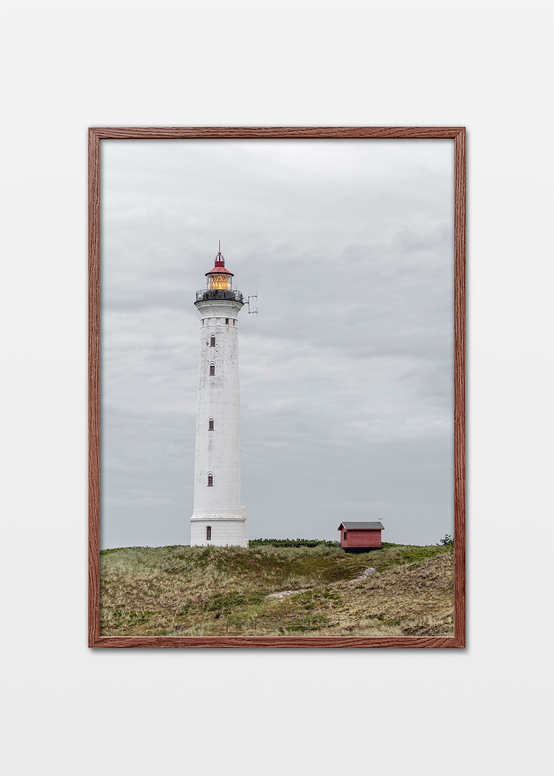 Lyngvig Fyr ved Hvide Sande med klitter, grå himmel og tændt lanterne