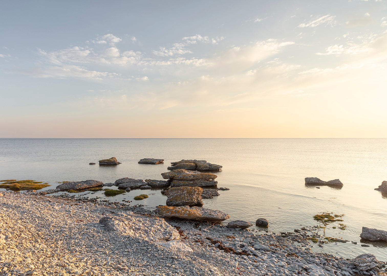Morgenlys over kysten ved Grogarnshuvud på Gotland med stenformationer i vandet.