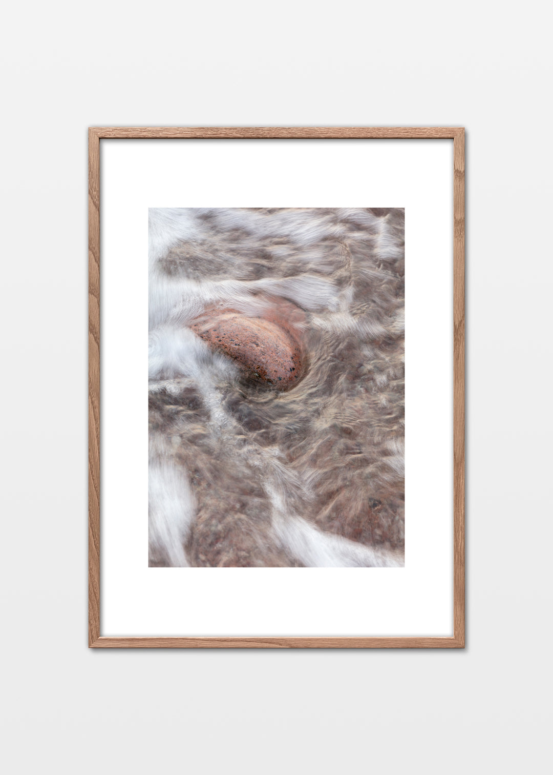 Plakat med Nærbillede af strandssten på Gotland med bløde bølger omkring.