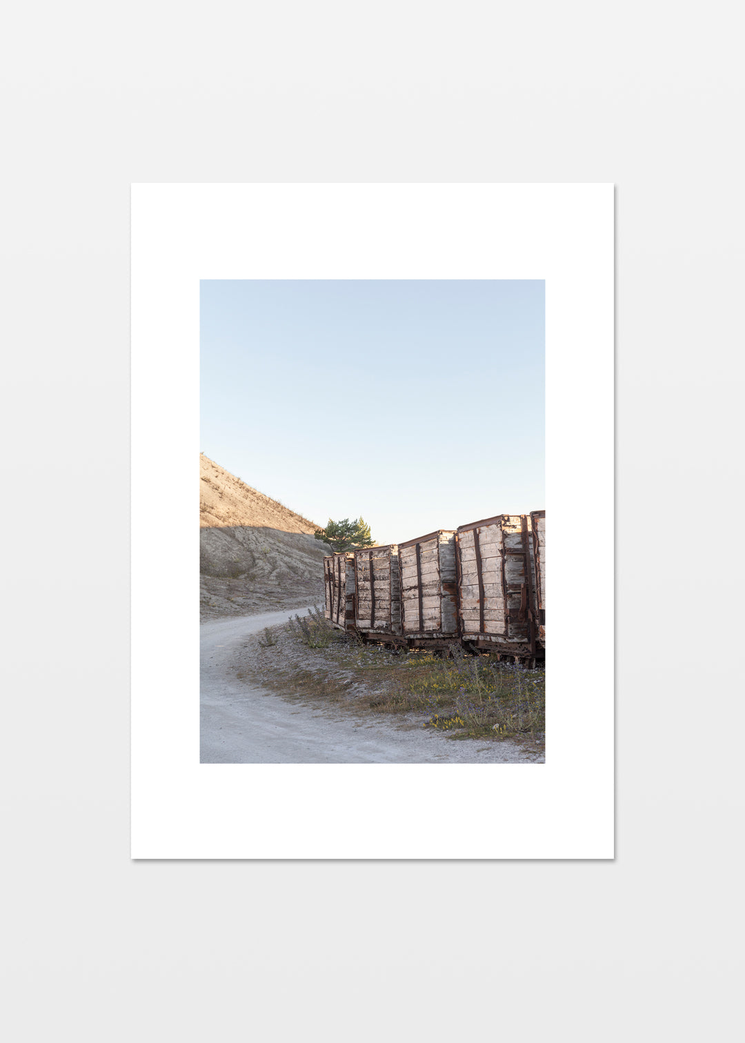 Gamle togvogne langs en kurvet vej i fabriksområdet ved Fabriken Furillen på Gotland.