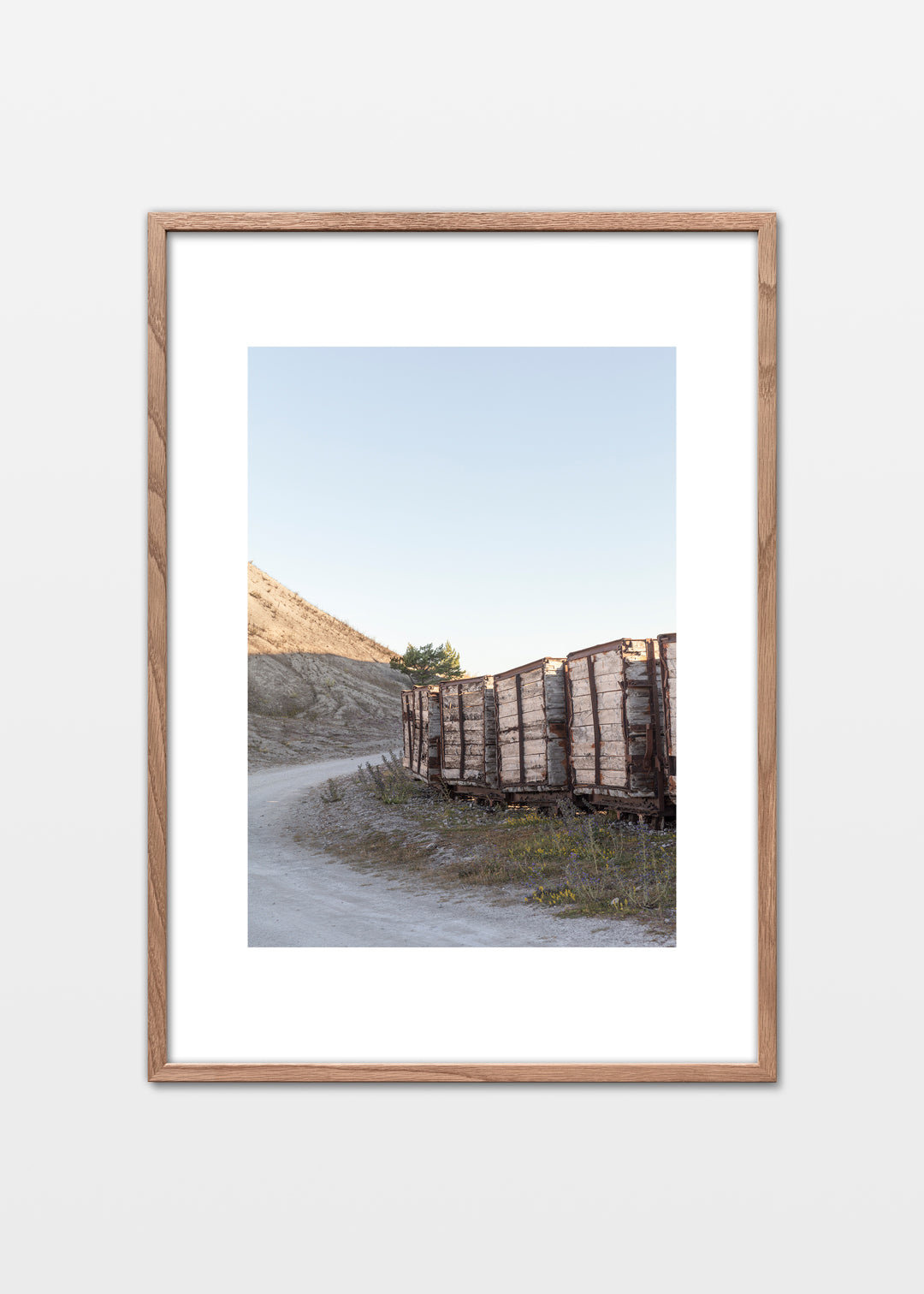 Gamle togvogne langs en kurvet vej i fabriksområdet ved Fabriken Furillen på Gotland.